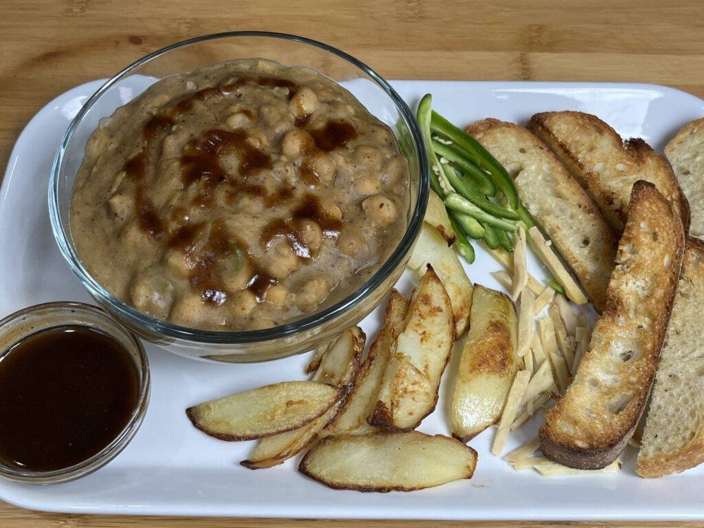 A bowl of Chola Chaat with chickpeas, vegetables, and spices
