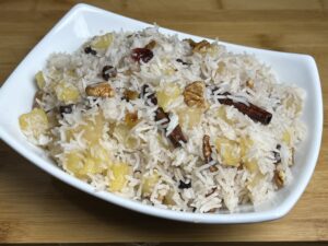 A bowl of Sweet Apple Pulao Rice garnished with apple slices and nuts
