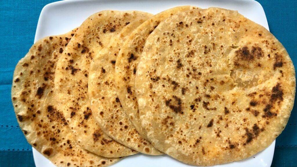 A plate of Coconut Paratha served with a side of yogurt
