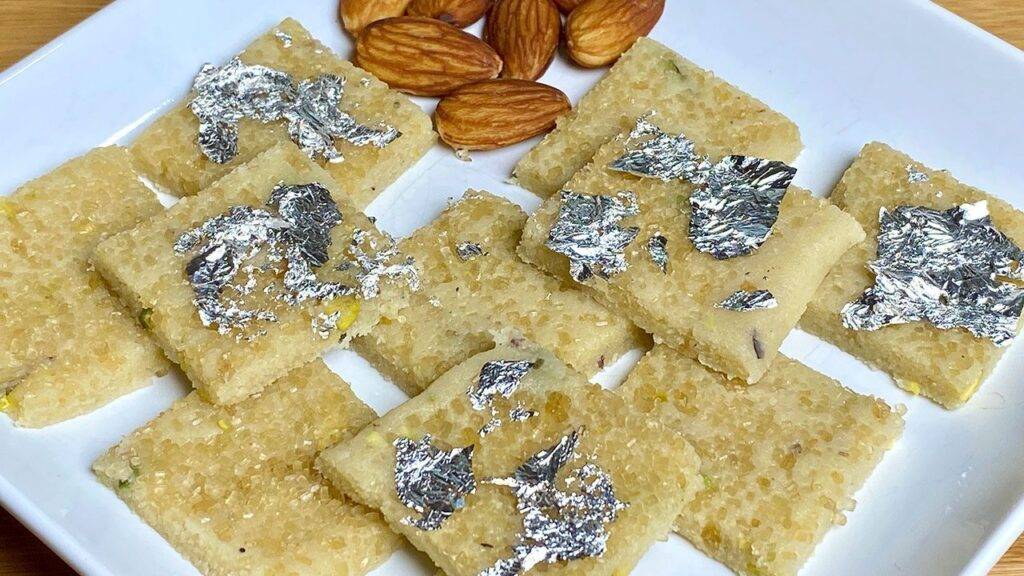 A plate of Instant Badam Burfi garnished with edible silver foil and almonds