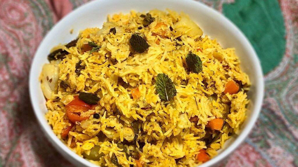 A bowl of Vegetable Biryani garnished with fresh mint leaves
