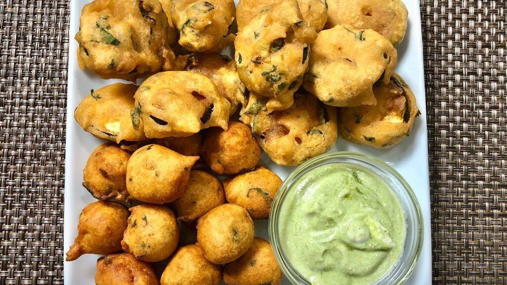 A plate of crispy Zucchini Lentil Pakoras served with chutney